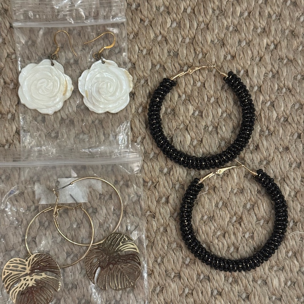 Three new pairs of Earrings.Black and Gold Hoops. White roses.